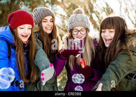 Le ragazze del Caucaso a soffiare bolle all'aperto in inverno Foto Stock