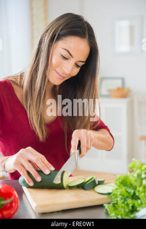 La donna caucasica per affettare le verdure per insalata Foto Stock