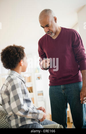 Razza mista nonno scolding nipote Foto Stock