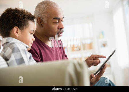Razza mista nonno e nipote utilizzando tavoletta digitale Foto Stock