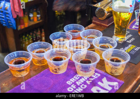 Jägerbombs sulla barra a viaggiatori amico ("Spivs'), pub, Woodford Green, Essex, Inghilterra pub tavola bicchieri di bevande Foto Stock