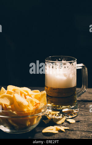 Bicchiere di birra con coppa di patatine Foto Stock