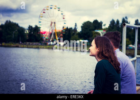 Coppia permanente al vicino lungomare ruota panoramica Ferris Foto Stock