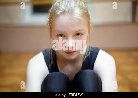 Caucasian ballerina seduta sul pavimento di studio Foto Stock