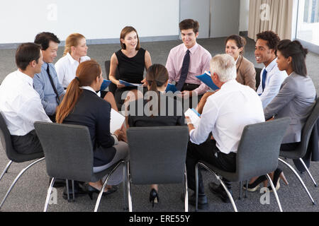 Gli imprenditori seduti in cerchio in seminario della società Foto Stock