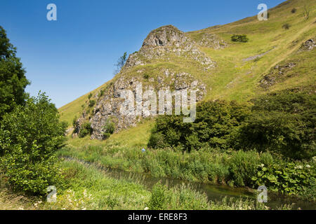 Regno Unito, Inghilterra, Staffordshire, Dovedale, Colomba di fiume che scorre al di sotto di sperone roccioso sulla collina Baley Foto Stock
