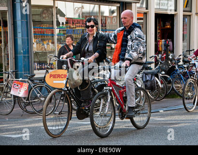 Paio di andare in bicicletta insieme per le strade di Amsterdam Foto Stock