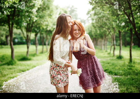 Due giovani ragazze felici Divertendosi in estate Park. I migliori amici di ridere e avvolgente. Foto Stock