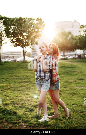 Giovani felici bella migliori amici ragazze in lo stile pin up abbracciando al tramonto. Il concetto di amicizia. Selective Soft Focus. Foto Stock