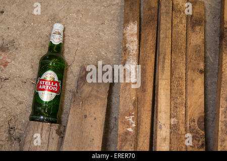 Una bottiglia inaperta di Stella Artois, camera abbandonata Foto Stock