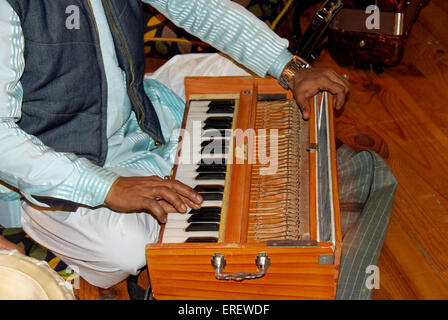 Close-up di Indian harmonium player con le mani in mano. Noto anche come peti o baja Foto Stock