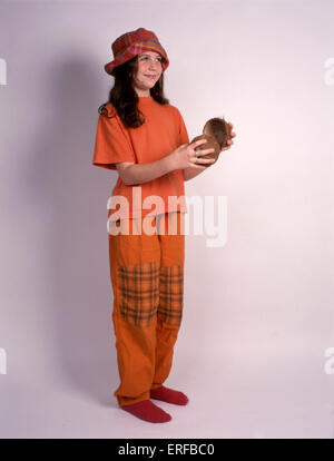 Primary School girl riproduzione di gusci di noce di cocco. In vestiti arancioni. Foto Stock