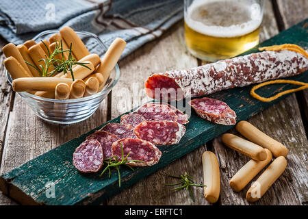 Fette di spagnolo di salsiccia di maiale sul tavolo con pane Foto Stock