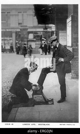 Un bootblack al lavoro, Londra. Mostra un bootblack brilla con un altro uomo scarpe. Foto Stock