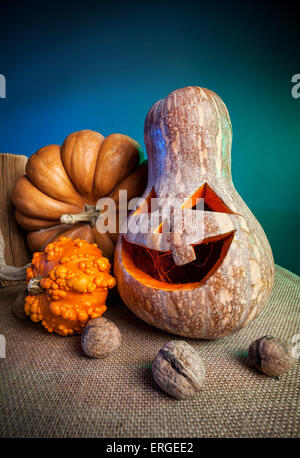 Scolpite di zucca e noci sul tavolo durante la festa di Halloween Foto Stock