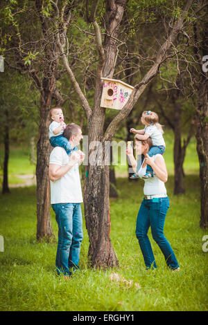 La famiglia felice con legno birdhouse Foto Stock