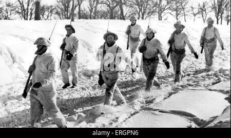 Durante la Seconda guerra mondiale - Inverno sul fronte occidentale, soldati con baionette marzo attraverso la neve. La didascalia recita: 'indossando white camouflage, Foto Stock