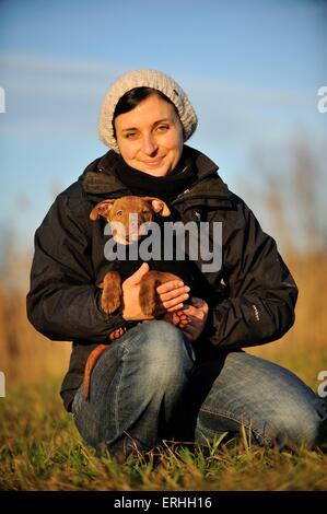 Donna con giovani Pitbull-mongrel Foto Stock