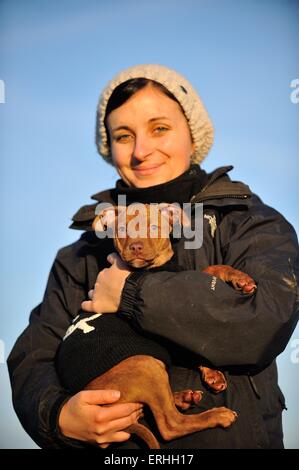 Donna con giovani Pitbull-mongrel Foto Stock