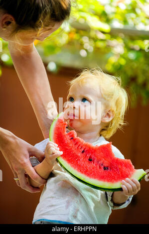 Carino neonato Bambino con una deliziosa cocomero Foto Stock