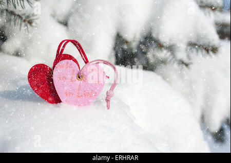 Cuore rosso giocattolo in nevicata sulla fir tree Foto Stock