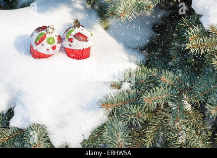 Giocattolo di natale torte su albero di inverno con nevicata Foto Stock