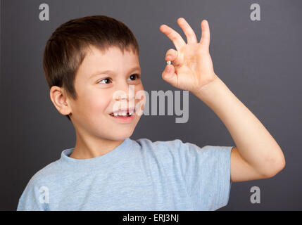 Ragazzo guarda al dente perduto Foto Stock