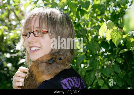 La ragazza con la fluidità di maiale hairedguinea Foto Stock