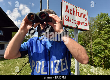 Mittenwald, Germania. 03 Giugno, 2015. Un funzionario di polizia su una piattaforma di osservazione al Ederkanzel mountain hotel controlla la zona di confine austro-tedesca regione dietro un cartello con la scritta "Attenzione - frontiera nazionale' vicino a Mittenwald, Germania, 03 giugno 2015. I capi di Stato e di governo del G7 Paesi si sono riuniti per il loro incontro al vertice dal 07 al 08 giugno 2015 a Schloss Elmau vicino a Garmisch-Partenkirchen. Foto: PETER KNEFFEL/dpa/Alamy Live News Foto Stock