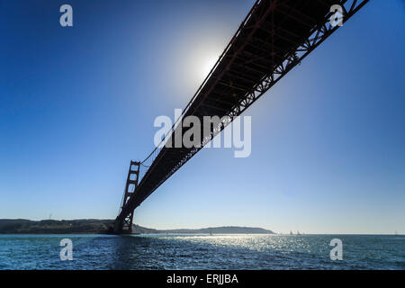 Sun parzialmente bloccati dalla campata del ponte Golden Gate si riflette sulla baia di San Francisco Foto Stock