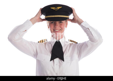 Femmina pilota senior in uniforme e che indossa il suo cappello e un cravat. Capitano regolando il suo cappello per un buon accoppiamento. Foto Stock