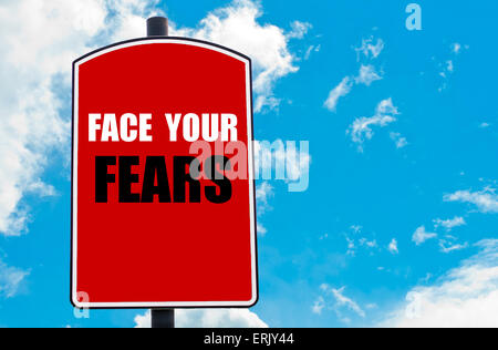 Affronta le tue paure motivazionali di preventivo scritto su Red road sign isolate su cielo blu chiaro dello sfondo. Foto Stock