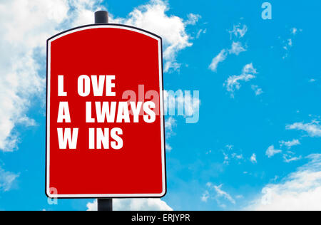 L'amore vince sempre motivazionali di preventivo scritto su Red road sign isolate su cielo blu chiaro dello sfondo. Foto Stock