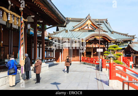 Giappone, Nishinomiya, Tempio di mondo Yakujin. Vista lungo Haiden, sala principale con persone di fronte a pregare, al santuario uffici, shamusho. Foto Stock