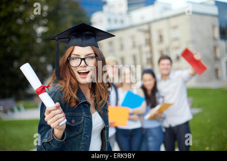 Gruppo di studenti sorridente con diploma e cartelle Foto Stock