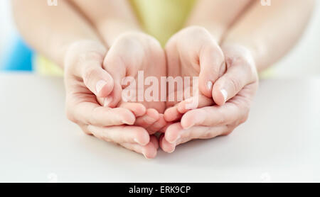 Close up di donna e bambina con le mani a tazza Foto Stock