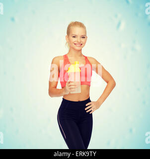 Sorridente sportivo da donna con la proteina agitare la bottiglia Foto Stock