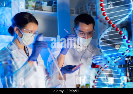 Gli scienziati con le pipette e le provette in laboratorio Foto Stock