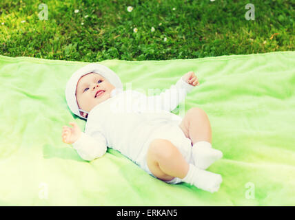 Sorridente baby sdraiato sul pavimento e guardando in alto Foto Stock