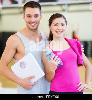 Due persone sorridenti con scala in palestra Foto Stock