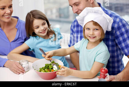 Felice famiglia con due bambini cottura a casa Foto Stock