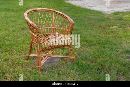 Vuota la sedia di vimini in giardino Foto Stock