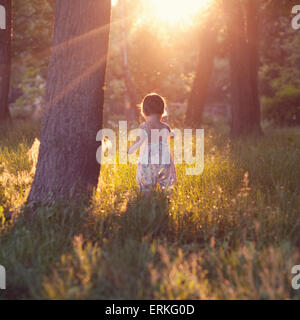 Bambino a piedi nelle luci del tramonto Foto Stock