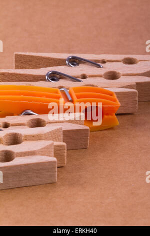 Chiudere dettagliato in vista laterale esplosa clothespins in legno con un'arancia uno, su sfondo di cartone. Foto Stock