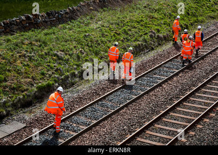 Diversi ingegneri ferroviari e ingegneri ferroviari di rete su Settle Carlisle Line, Health and Safety for Men at Work a Tebay, Cumbria, che lavorano per la manutenzione dei binari ferroviari. Ispettori, ingegneri della sicurezza, dipendenti, ferrovieri, operai, rinnovamento delle linee ferroviarie e degli ispettori dell’infrastruttura che ispezionano e misurano i binari della linea di trasporto merci in cima all’AIS Gill. La vetta della ferrovia, a 1.169 piedi (356 metri), si trova a nord di Garsdale, è la linea principale più alta in Inghilterra e trasporta treni merci di linea principale molto carichi. Foto Stock