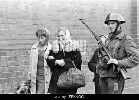 Belfast, Irlanda del Nord, 14 agosto 1969. Alice Rooney, madre di nove anni di Patrick, grida di angoscia dopo che suo figlio è stato ucciso da una pallottola vagante mentre a casa nella sua camera da letto. Ella è scortato da er sorella come un soldato britannico guarda a. Foto Stock