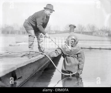 Antiquariato fotografia 1929, diver John Robinson in vestito standard da diving a Harvard il Newell casa in barca sul fiume Charles, Cambridge, Boston, Massachusetts, USA. Foto Stock