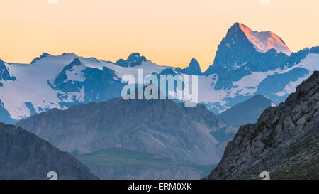 Ultimo rosso luce solare che colpisce il ghiacciaio sulla maestosa vetta della Barra degli Ecrins (4101 m), Francia. Teleobiettivo con vista da lontano Foto Stock