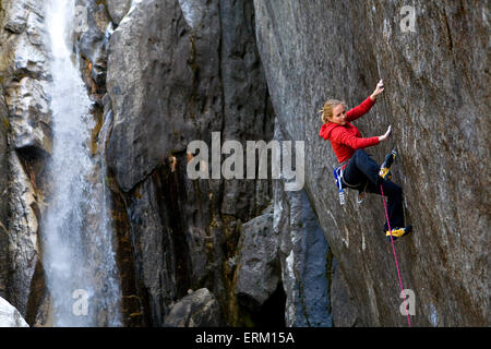 Donna salire al di sopra di un fiume vicino alla cascata nel Parco Nazionale di Yosemite in California. Foto Stock