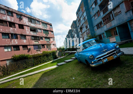 Una classica macchina americana è visto parcheggiato di fronte al blocco di appartamenti in Bahía, un alloggiamento pubblico sobborgo di l'Avana, Cuba. Foto Stock